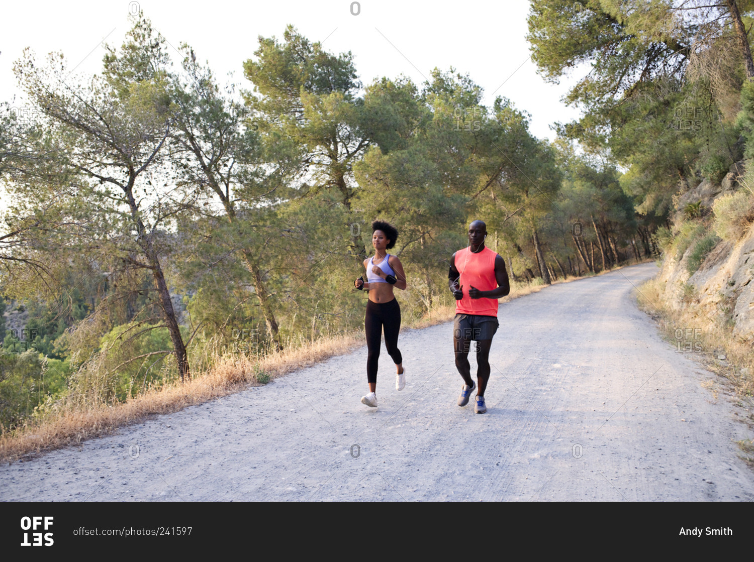 Athletic couple running on rural road
