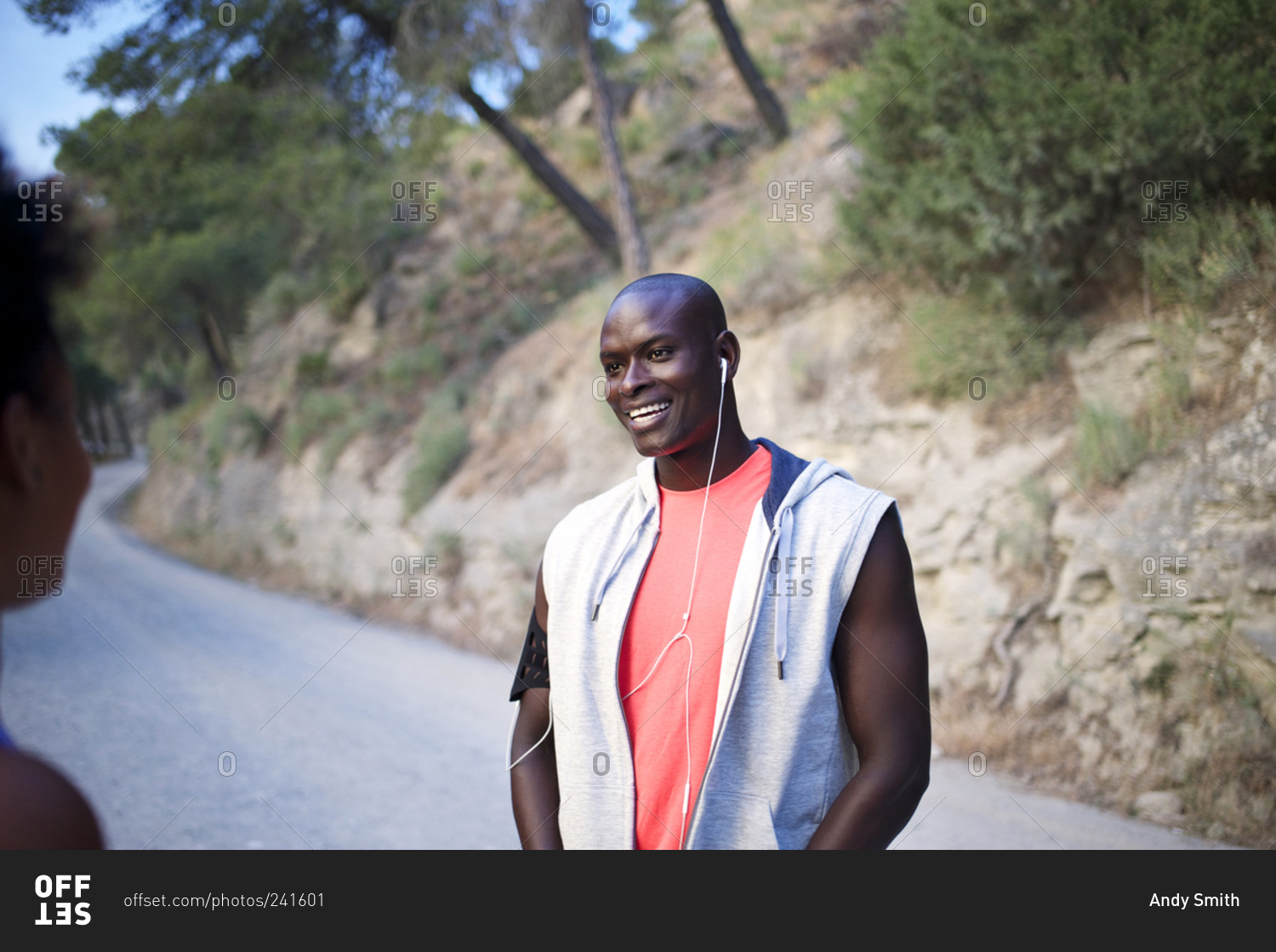 Athletic man smiling at friend on rural road