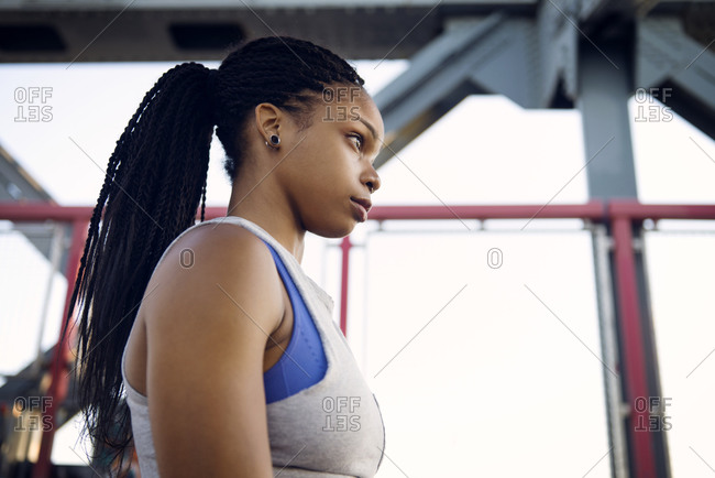 An athlete with piercings stands on a bridge