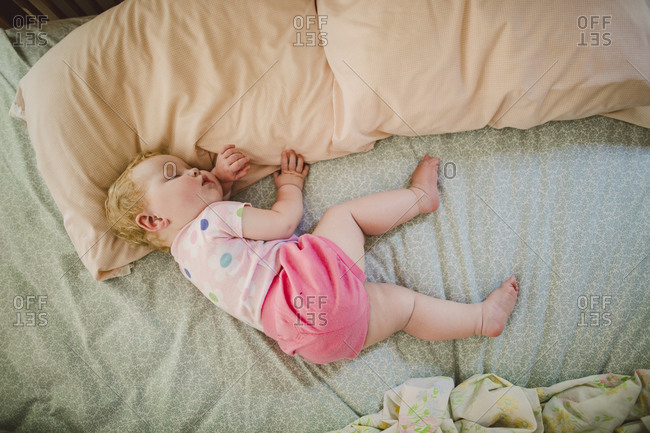 Peaceful baby girl asleep on a big bed