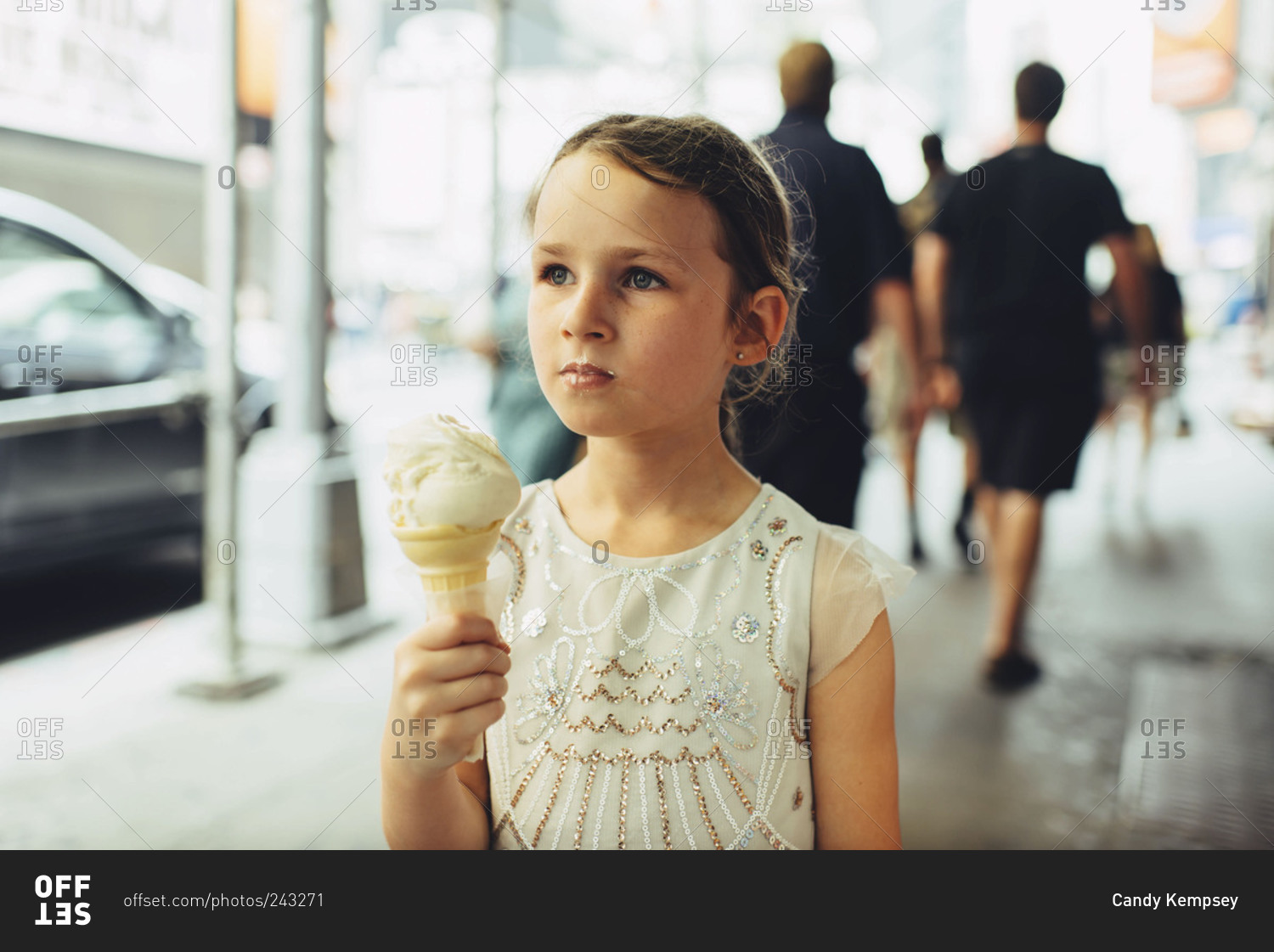 Portrait of girl eating ice cream on city sidewalk