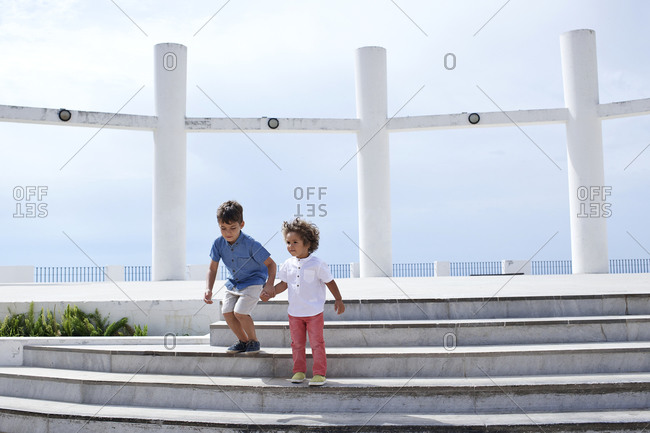 Brothers playing on steps at a scenic overlook