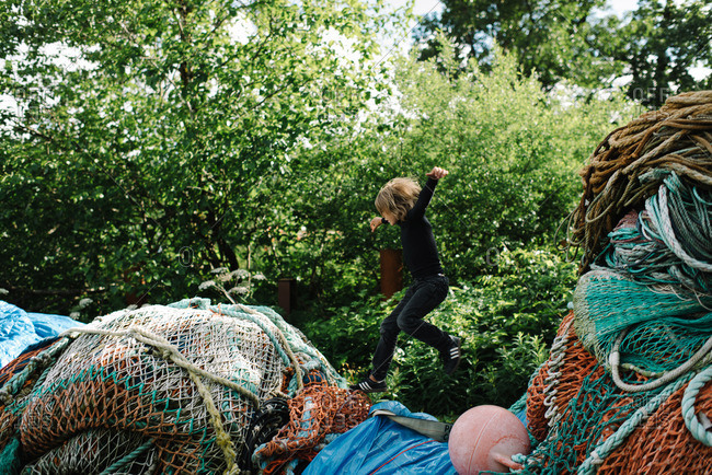Boy leaping across fishing nets