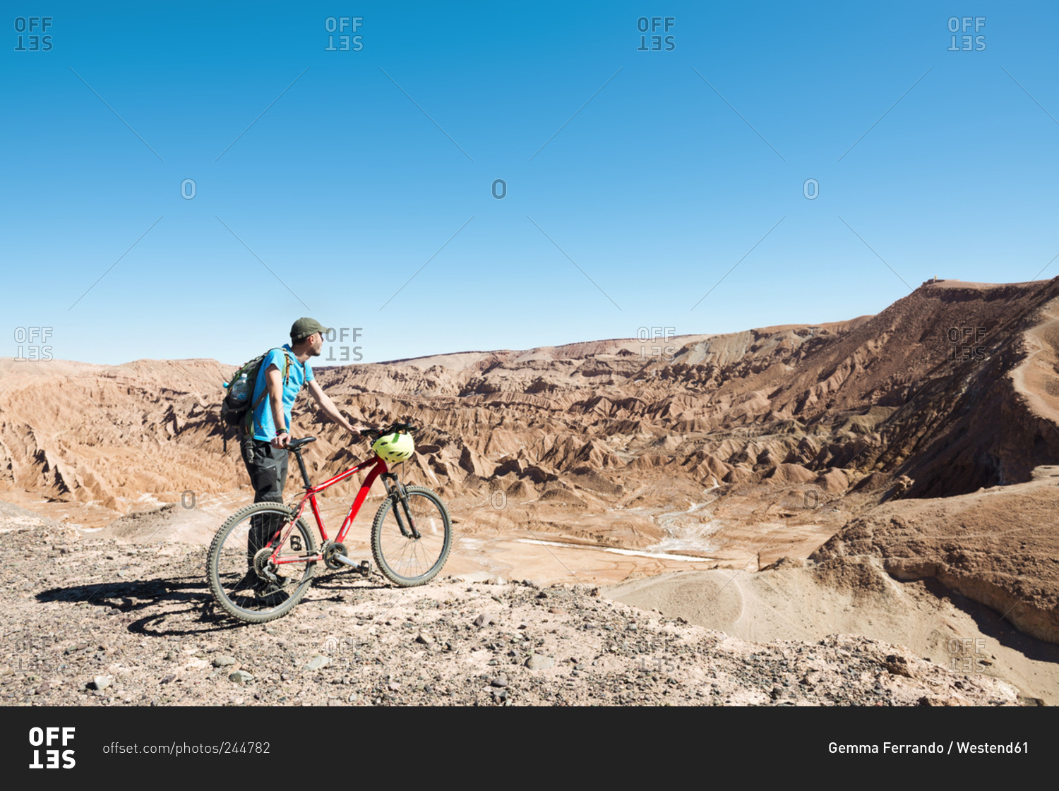Man holding a mountain bike and looking to the Death Valley in the Atacama Desert