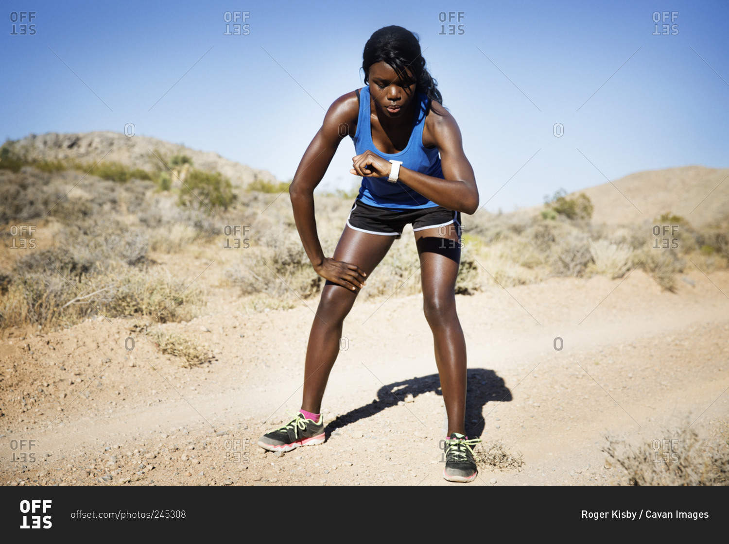 Athletic woman in remote setting checking watch