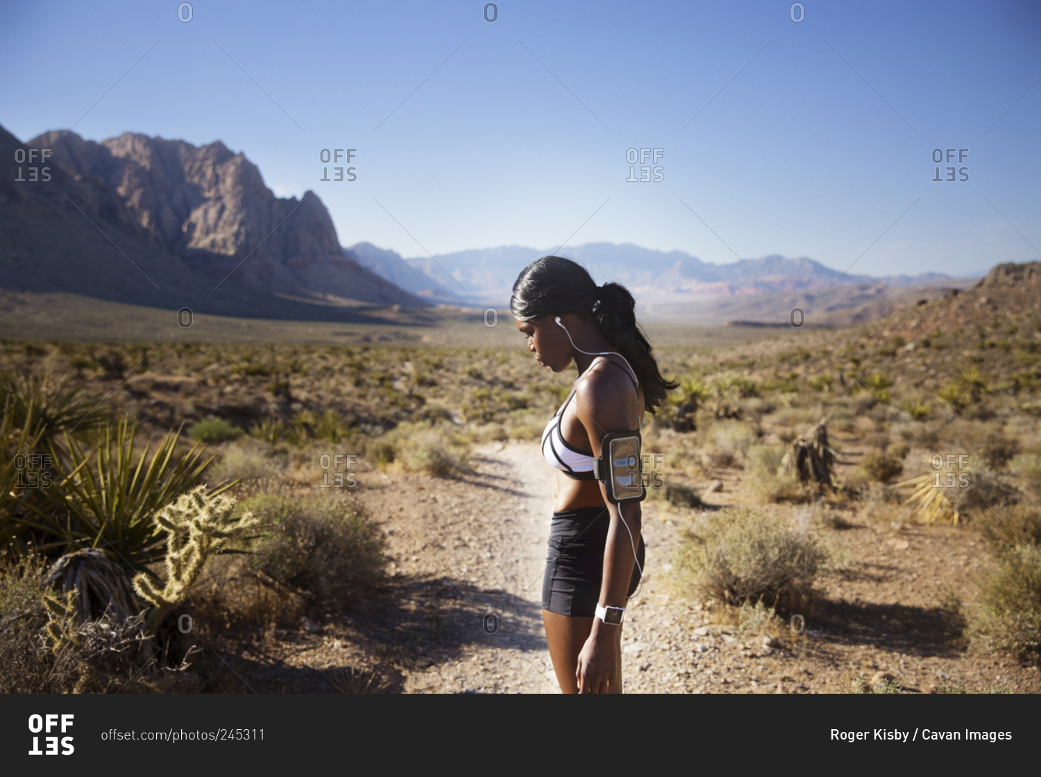 Athletic woman listening to music in desert