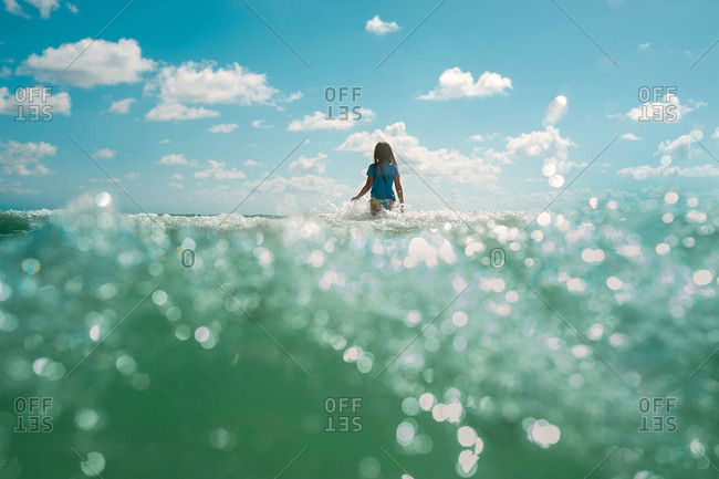 girl stepping into the waves