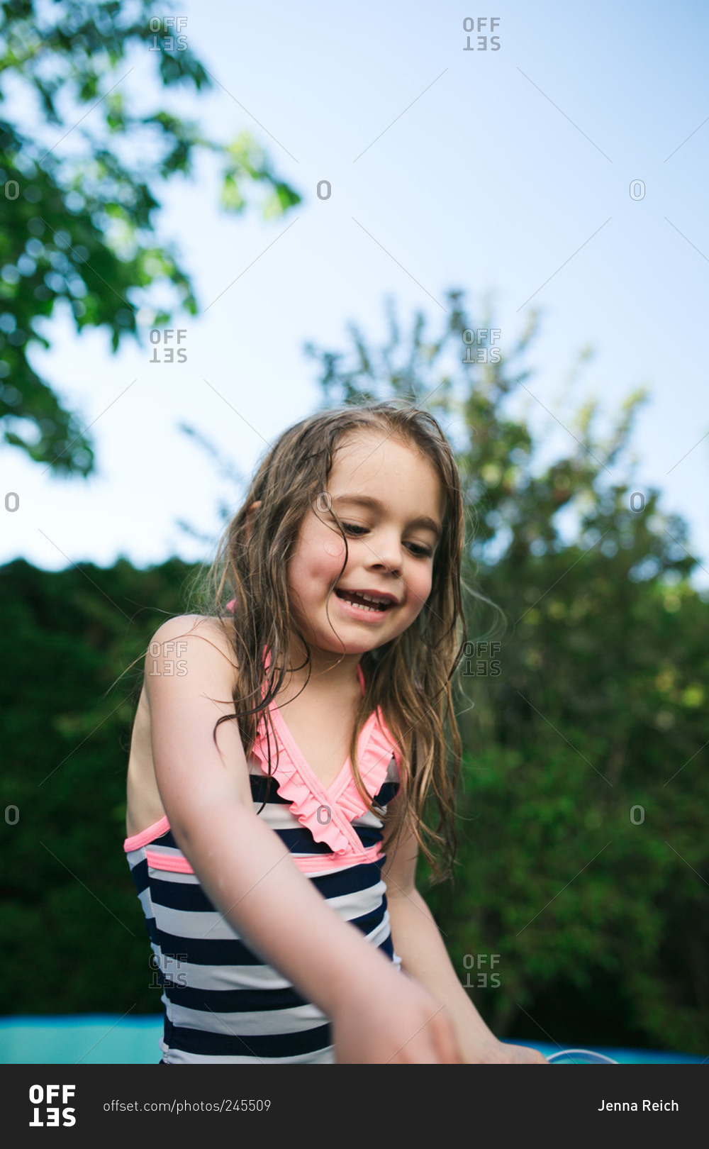 Little girl smiling in kiddie pool stock photo OFFSET