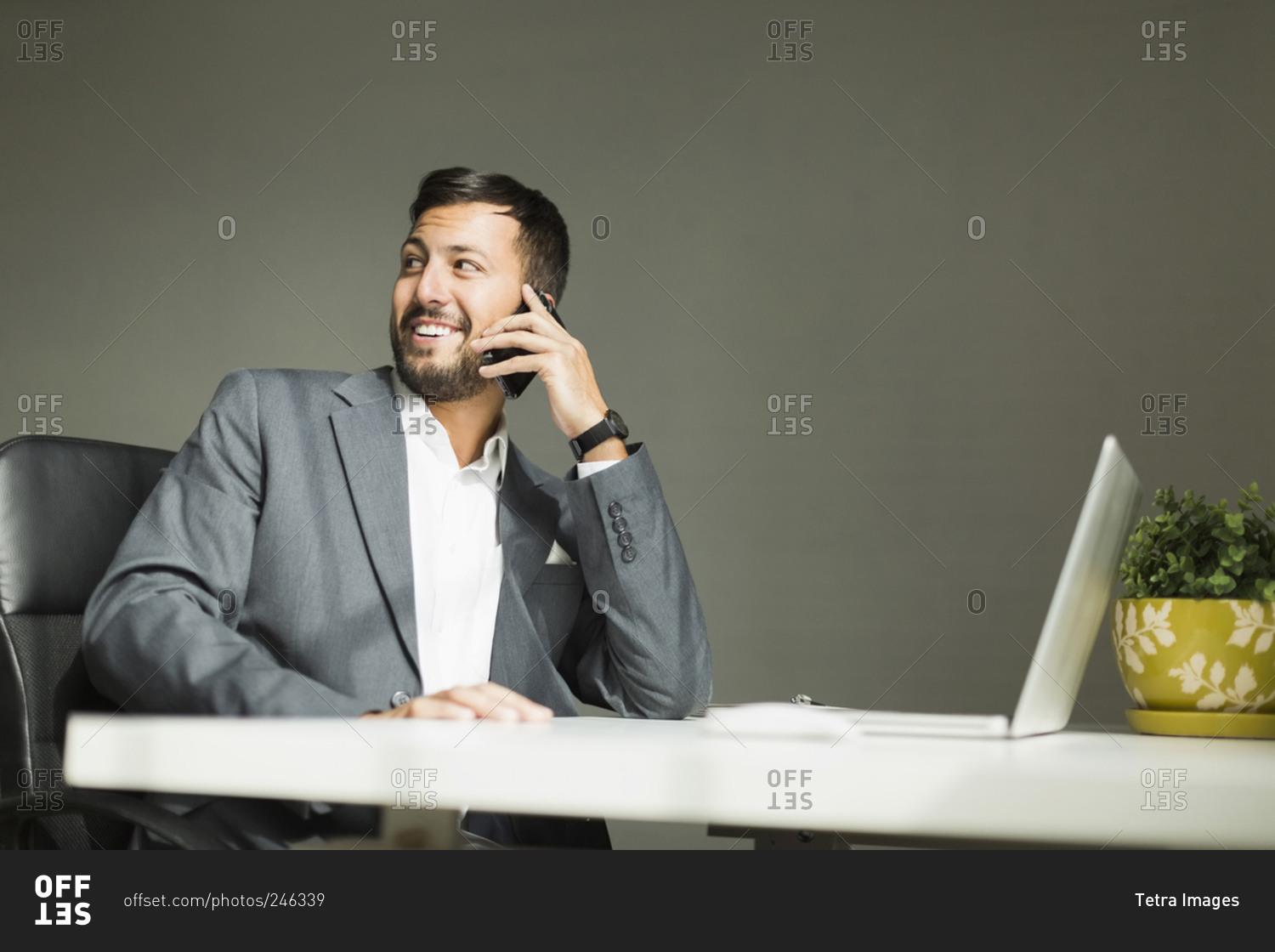 Young man sitting at desk and talking on phone