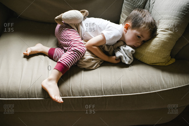 Little Sick Boy Curled Up On A Couch Stock Photo Offset