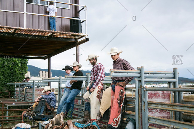 Taos, New Mexico, USA - June 28, 2015: Rodeo cowboys leaning against railing