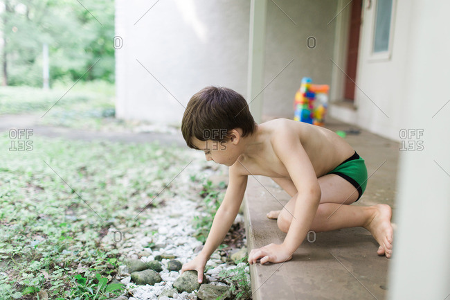 Children in underwear playing stickball in backyard stock photo - OFFSET