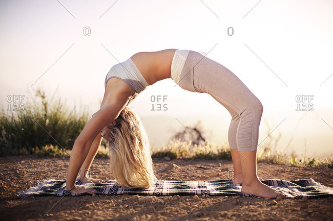 A close up view on the bare foot of a flexible woman practicing advanced  yoga stretches, sitting on the gym floor stretching hand towards toes Stock  Photo - Alamy