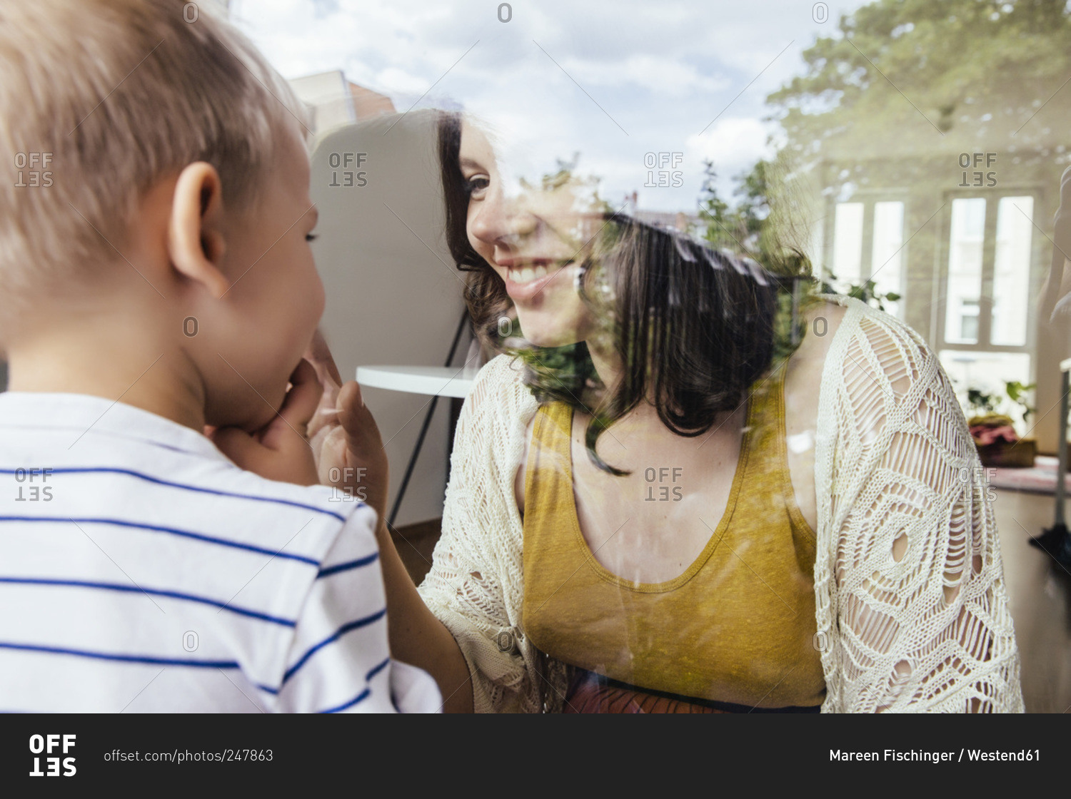 Mother and son making contact through a window