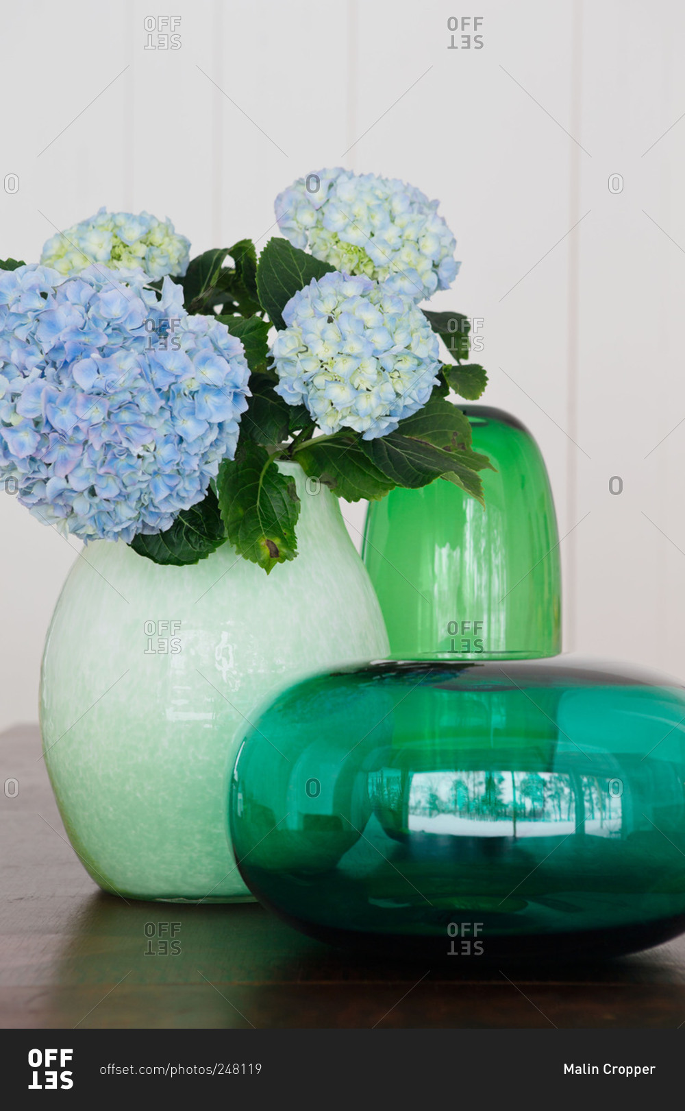 Blue hydrangeas in a green vase in a home in Sweden