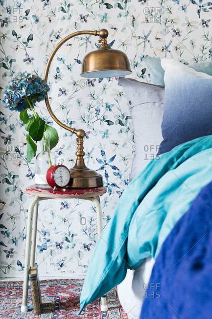 A bedroom with blue and white floral wallpaper