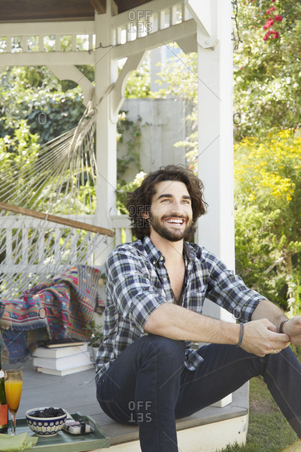 A man sits in a gazebo and smiles