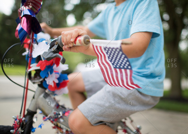 A boy rides a bike decorated for the Fourth of July