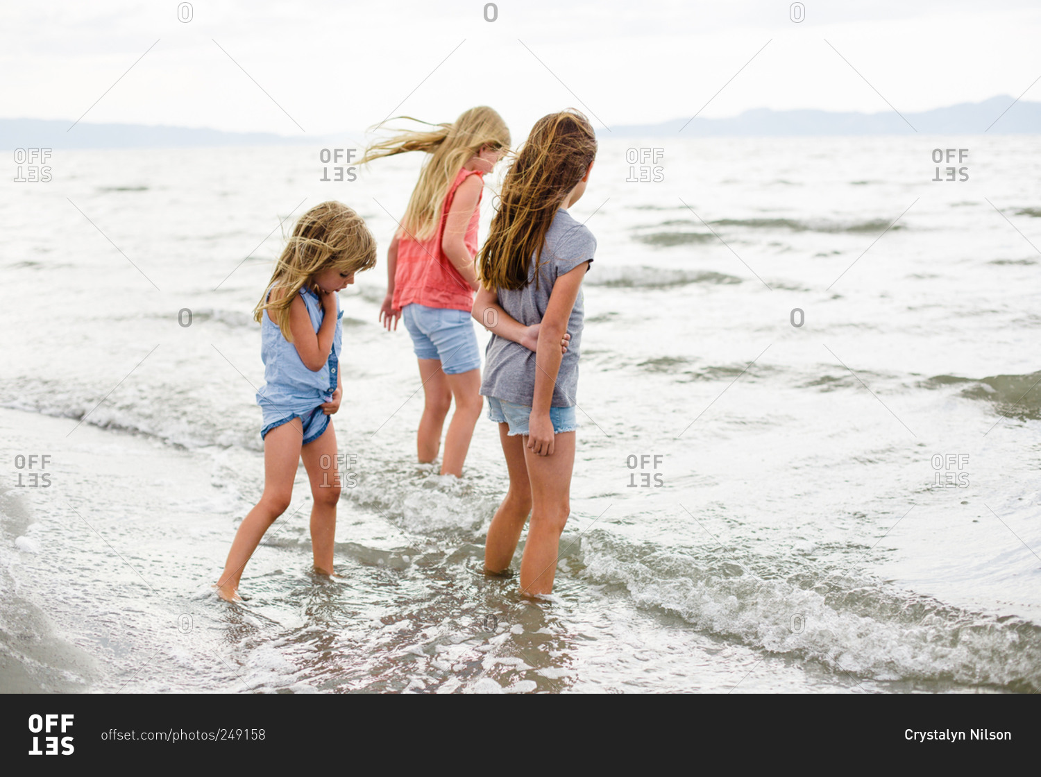 Three Girls Wading In Shallow Lake Water Stock Photo Offset