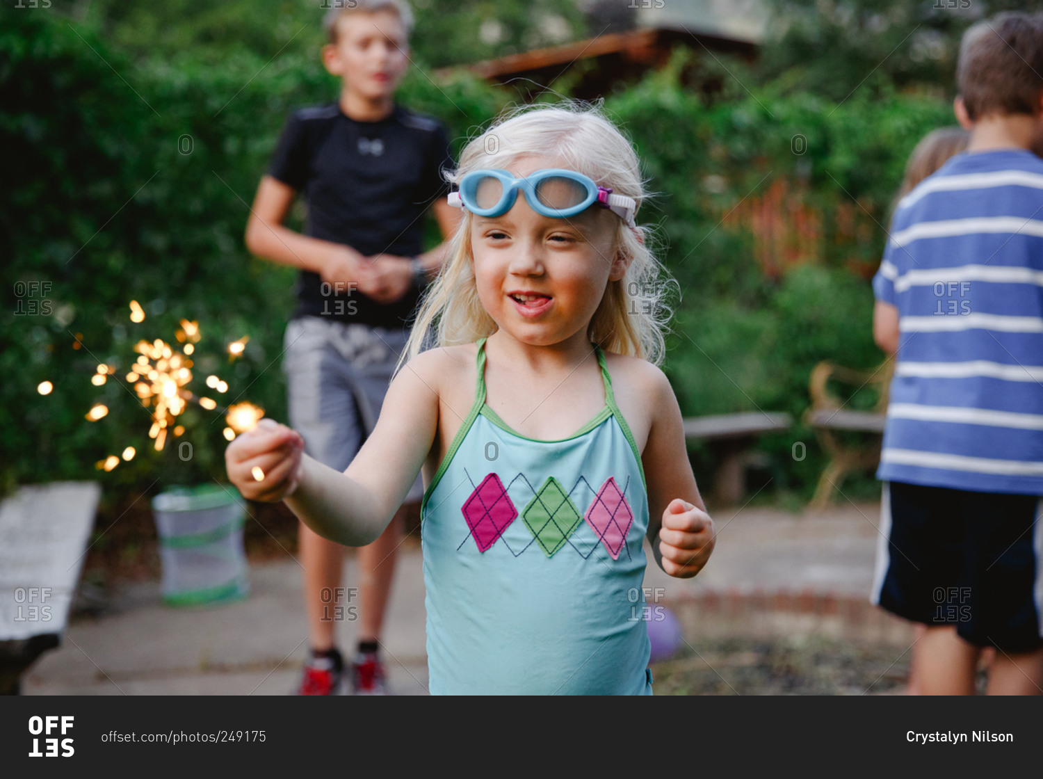 Kids playing with sparklers in the backyard