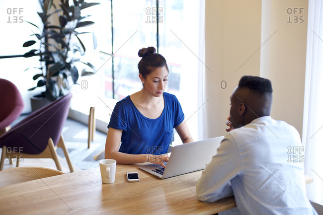 Multi ethnic coworkers together at table with laptop