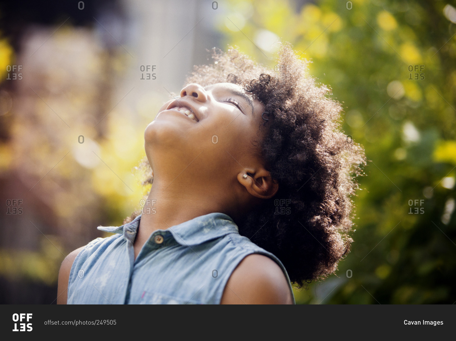 Girl throwing her head back and enjoying the sun stock photo OFFSET