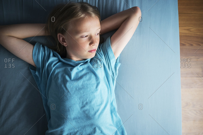 A boy rests on a bed