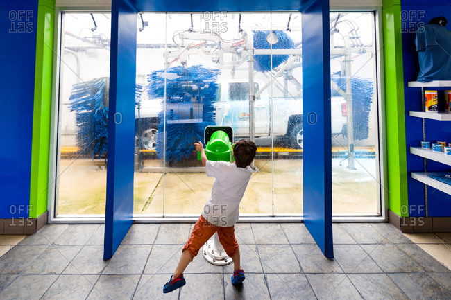 Young boy watching truck being washed in car wash