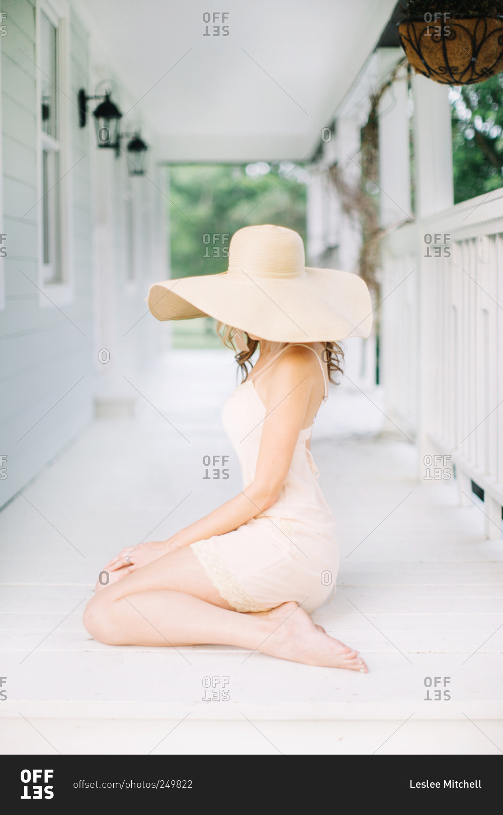 Woman wears a summer hat on a porch