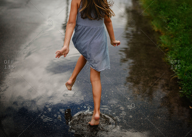 Girl Running Barefoot Through A Puddle On The Street Stock Photo Offset