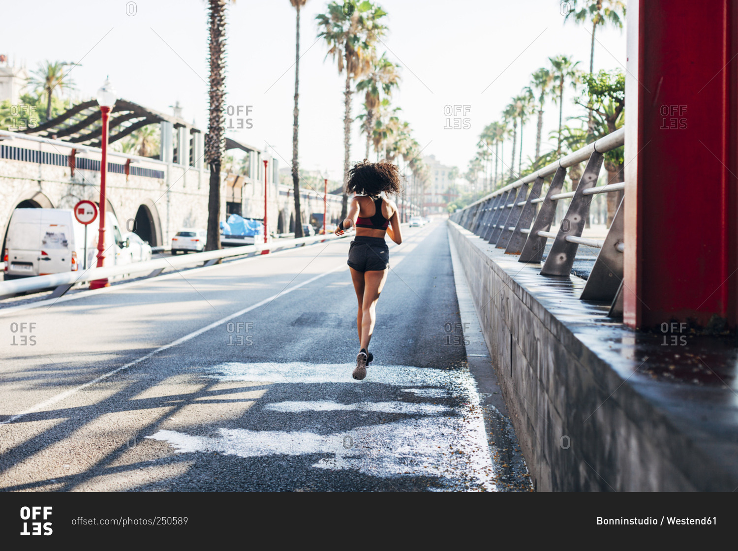 Back view of jogging young woman on a street
