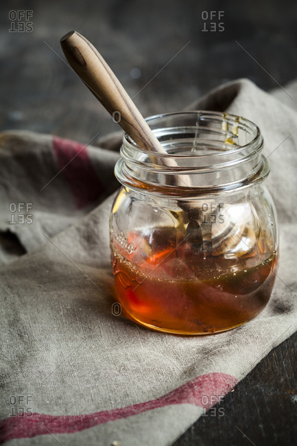 Honey in glass with wooden honey spoon