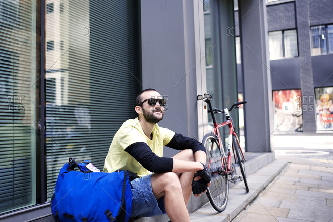 Cyclist sitting on a city sidewalk