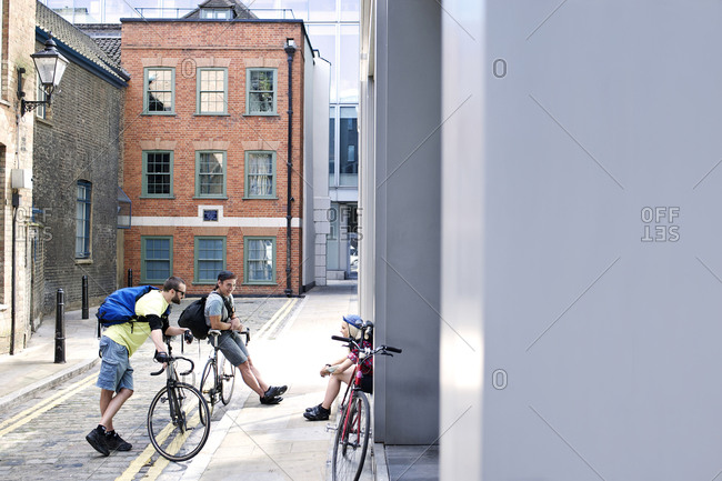 Cyclists having a conversation in an alley
