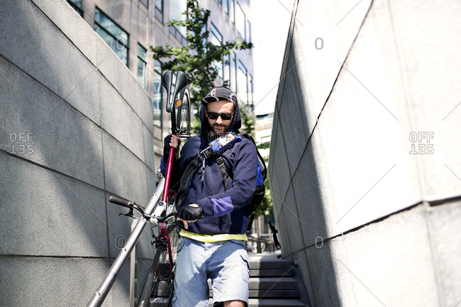Man carrying his bike down steps