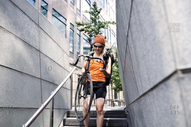 Woman carrying a bike down steps