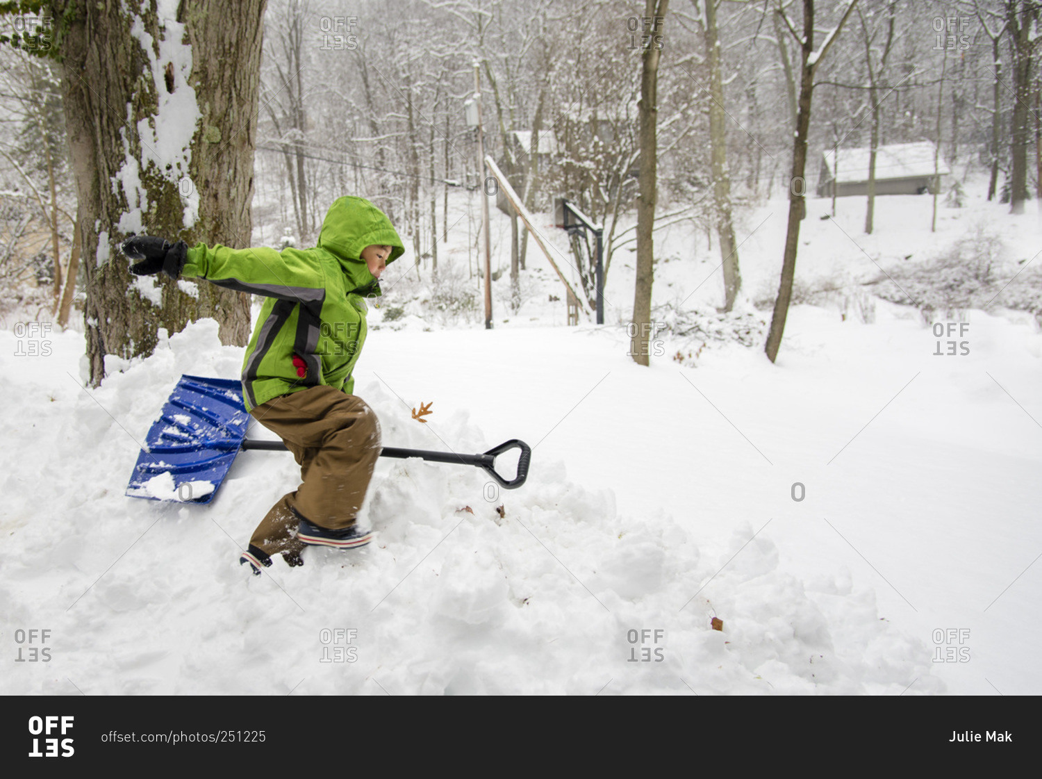 Young boy with snow shovel in deep snow