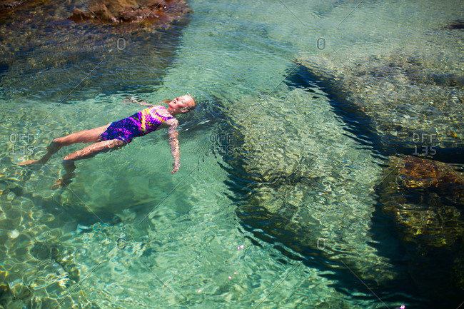 Blissful girl floating on her back in the ocean