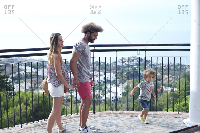 Family standing on a balcony overlooking a town in the countryside