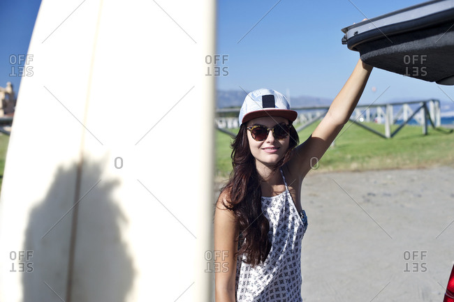 Woman at a beach closing the back of a vehicle