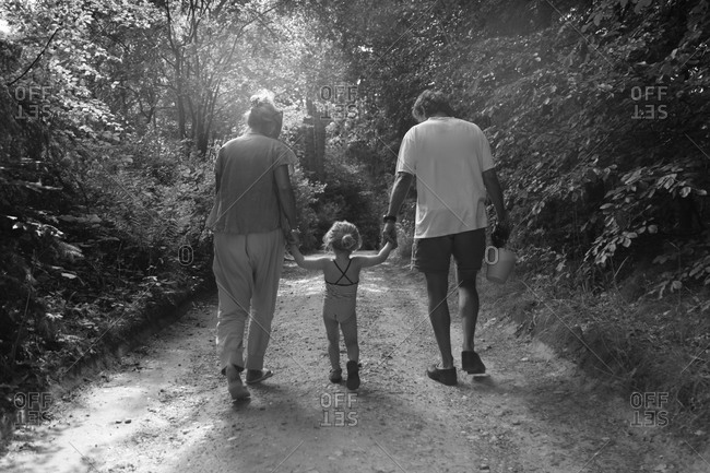 Woman and man walking on path with child
