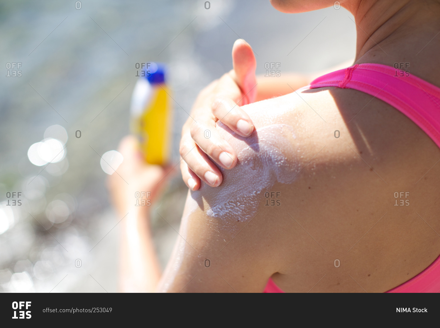 Woman applying sun lotion to her shoulder
