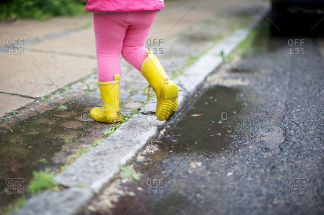 A girl in rain clothes at roadside