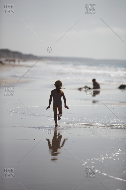 Naked girl running in water