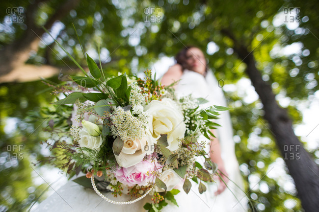Low angle view of bride holding bouquet of flowers