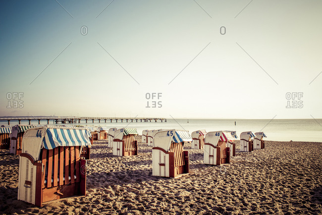 View to Timmendorfer Strand with hooded beach chairs at sunrise, Niendorf