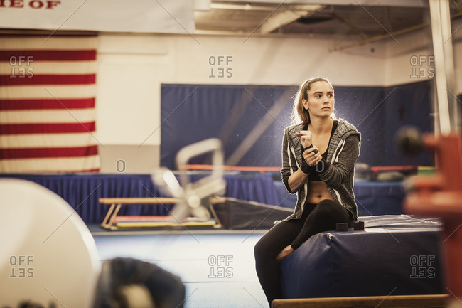 A gymnast takes a break during practice