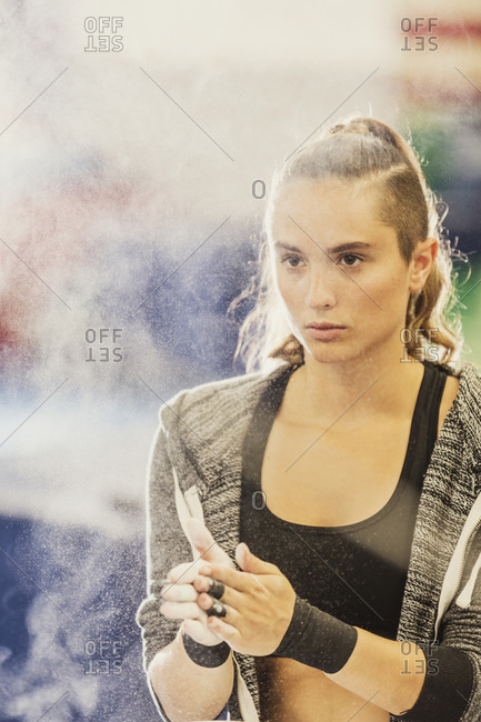 A gymnast chalks her hands