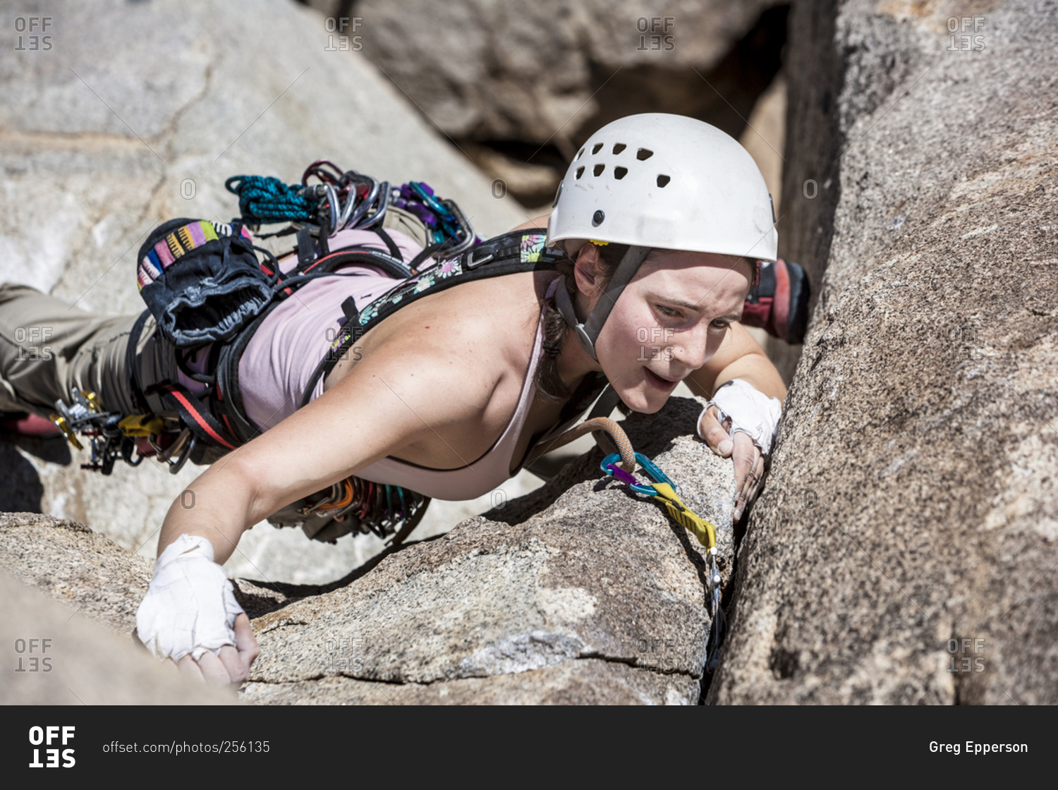 Female climber scaling up a crack