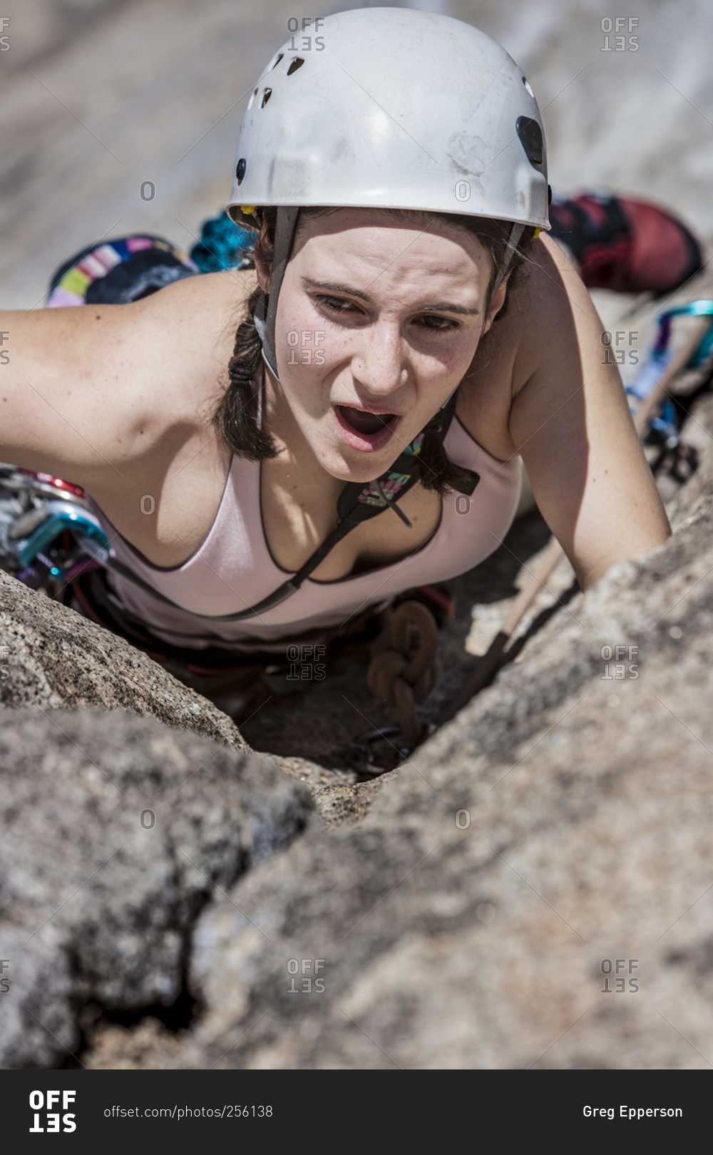 Female climber scaling cliff face stock photo OFFSET